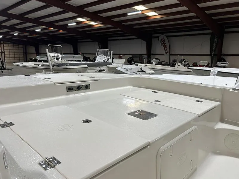 Slide: The Image of 2025 Carolina Skiff 21 LS boat interior in showroom, showcasing spacious deck and storage compartments. - 4