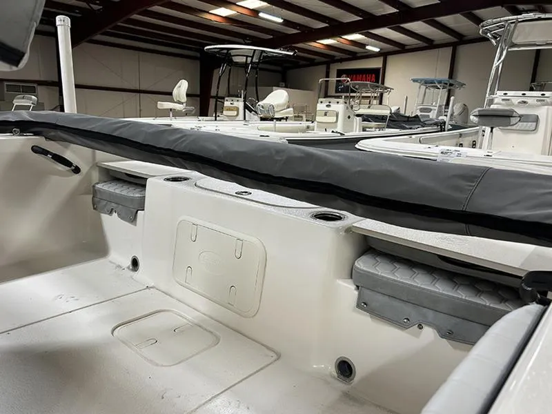 Slide: The Image of 2025 Carolina Skiff 21 LS boat interior, featuring seating and storage in a showroom setting. - 6