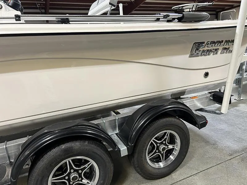 Slide: The Image of 2025 Carolina Skiff 21 LS boat on trailer, side view in indoor setting. - 8