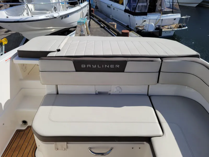 Slide: The Image of 2019 Bayliner VR6 Bowrider I/O boat interior with cushioned seating at a marina. - 12