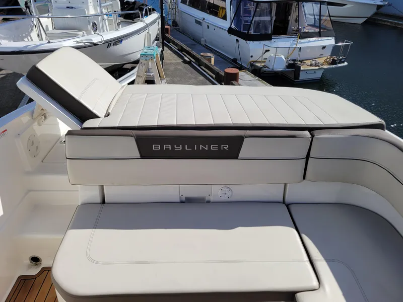 Slide: The Image of 2019 Bayliner VR6 Bowrider I/O boat interior with cushioned seating at a marina. - 13