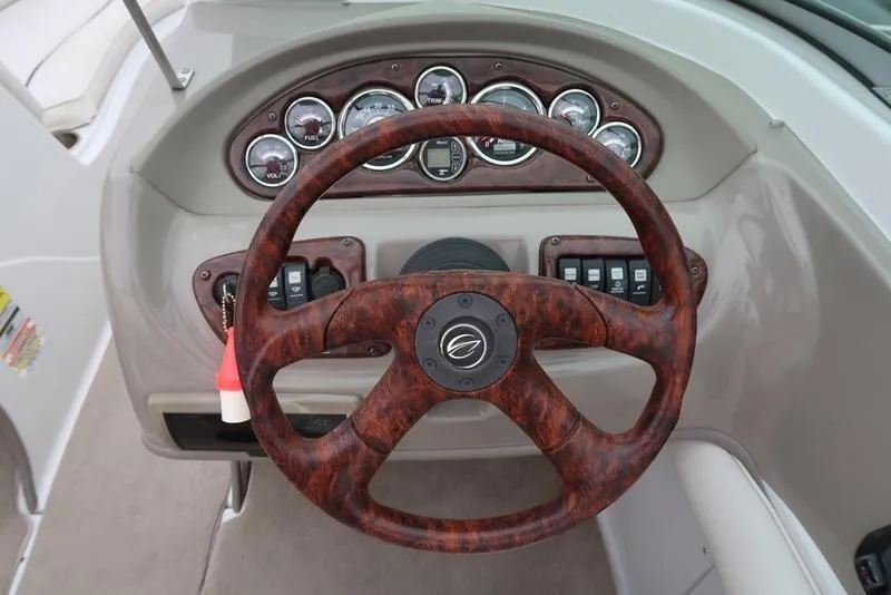 Slide: The Image of Steering wheel and dashboard of a 2008 Crownline 21LS boat, featuring gauges and controls. - 13