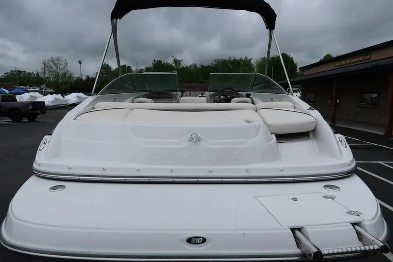 Slide: The Image of 2008 Crownline 21LS boat with white exterior, rear view, parked outdoors under cloudy skies. - 4