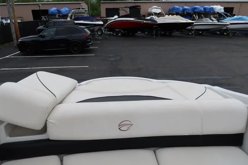 Slide: The Image of 2008 Crownline 21LS boat interior with white seating, parked in a lot with other boats. - 6