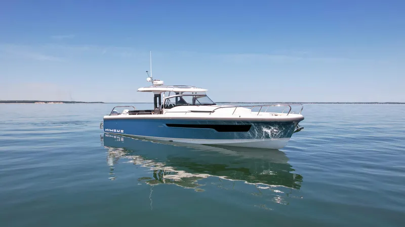 Slide: The Image of 2025 Nimbus T11 boat on calm water under clear blue sky. - 1