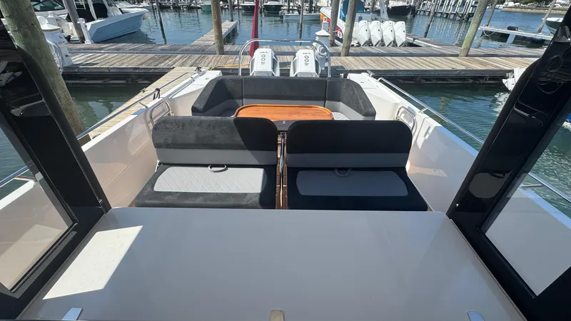 Slide: The Image of 2025 Nimbus T11 boat interior with seating and table, docked at marina. - 15