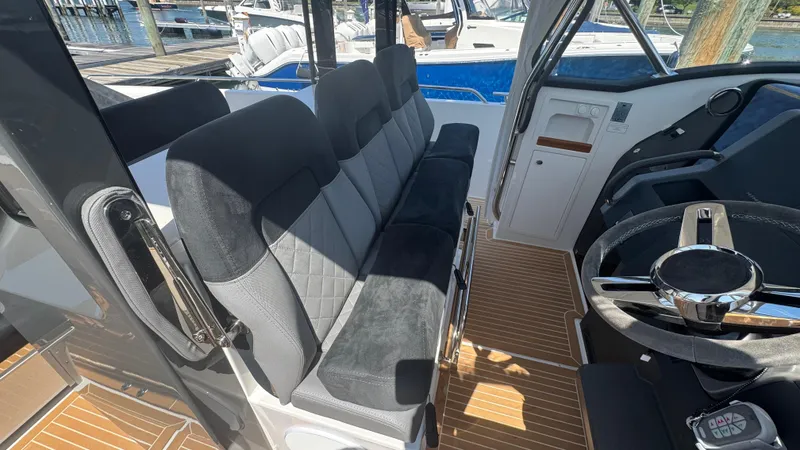 Slide: The Image of Interior of 2025 Nimbus T11 boat with plush seating and modern steering wheel. - 24