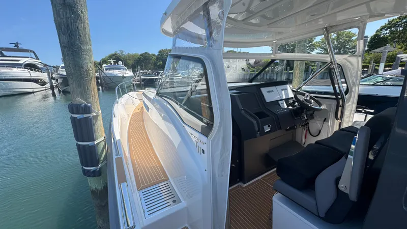 Slide: The Image of 2025 Nimbus T11 boat interior with modern dashboard, docked at marina. - 27