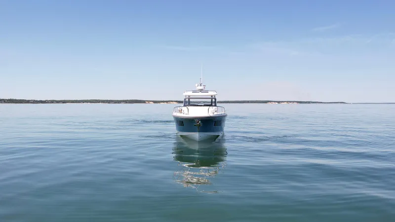 Slide: The Image of Front view of a 2025 Nimbus T11 boat on calm water under a clear sky. - 3
