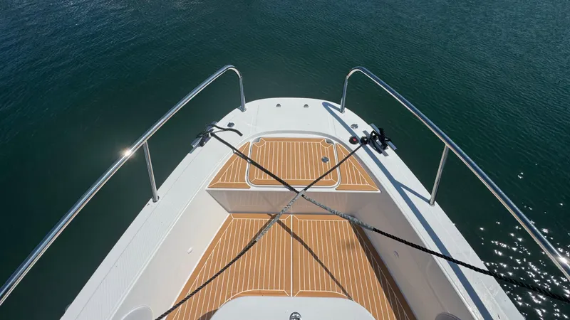 Slide: The Image of Bow of 2025 Nimbus T11 boat with teak decking on calm water. - 34