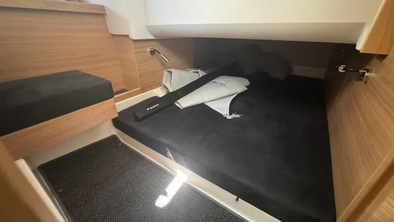 Slide: The Image of Cozy cabin interior of 2025 Nimbus T11 boat with wooden accents and black bedding. - 37