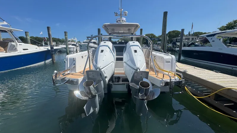 Slide: The Image of Sleek 2025 Nimbus T11 boat docked, showcasing dual outboard engines in a marina setting. - 8
