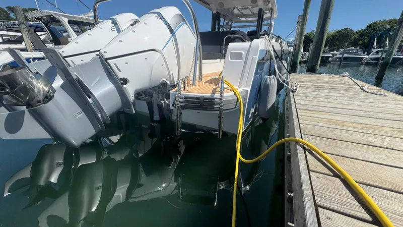 Slide: The Image of 2025 Nimbus T11 boat docked with dual outboard motors and yellow power cable. - 9