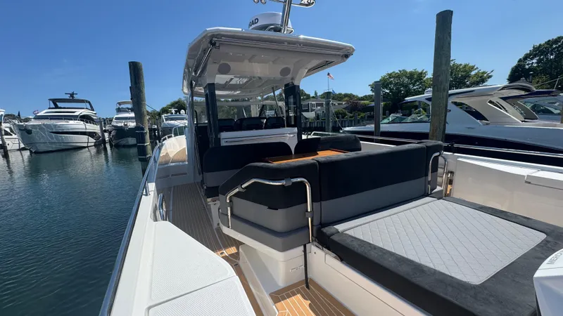 Slide: The Image of 2025 Nimbus T11 boat docked, featuring sleek design and spacious seating area. - 12