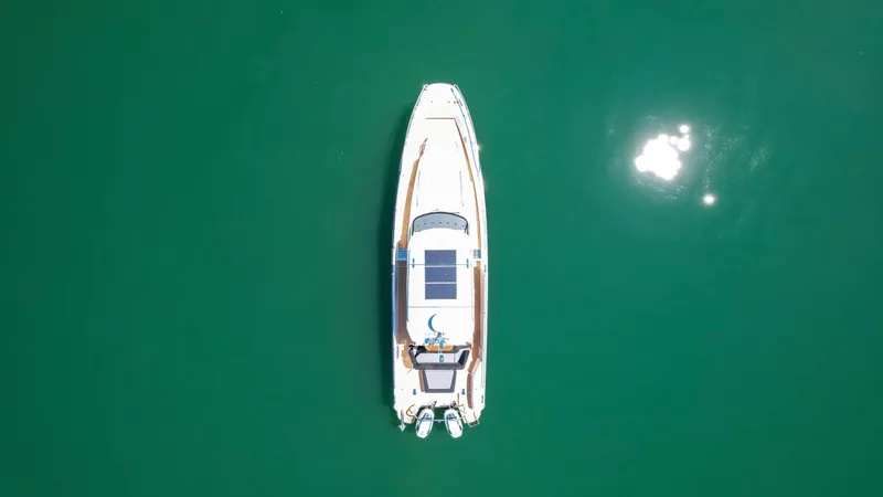 Slide: The Image of Aerial view of 2025 Nimbus T11 boat on calm green water. - 2