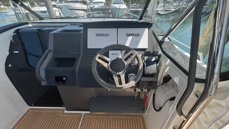 Slide: The Image of Helm of 2025 Nimbus T11 boat with Simrad navigation system and modern steering wheel. - 22