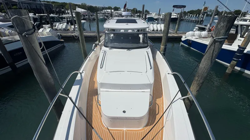 Slide: The Image of 2025 Nimbus T11 boat docked at marina, showcasing sleek design and spacious deck. - 31