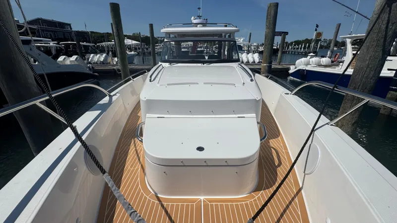 Slide: The Image of 2025 Nimbus T11 boat docked, featuring sleek white design and spacious deck. - 32