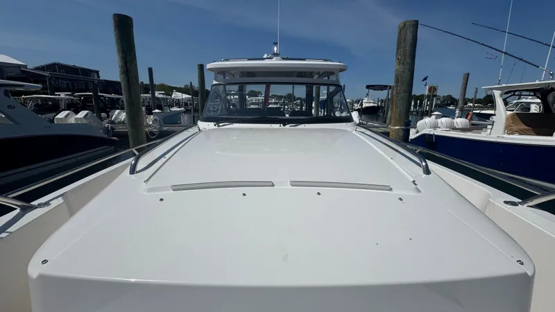 Slide: The Image of Nimbus T11 2025 boat docked at marina under clear blue sky. - 33