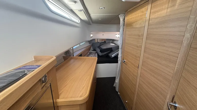 Slide: The Image of Luxurious interior of 2025 Nimbus T11 boat with wooden cabinetry and cozy sleeping area. - 35