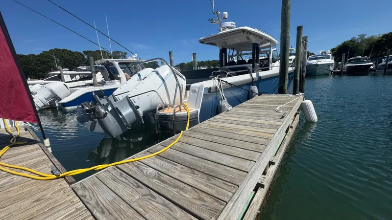 Slide: The Image of Nimbus T11 2025 boat docked at marina, clear blue sky, calm water. - 7