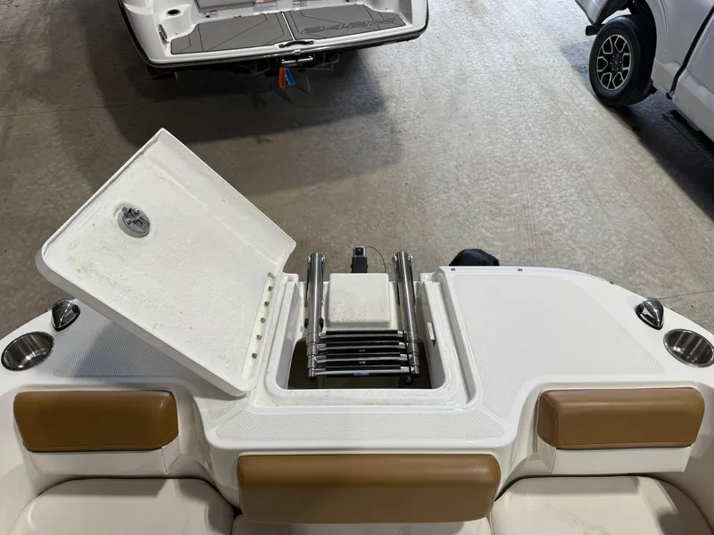 Slide: The Image of 2021 Bayliner DX2250 boat with open storage compartment and seating area. - 10