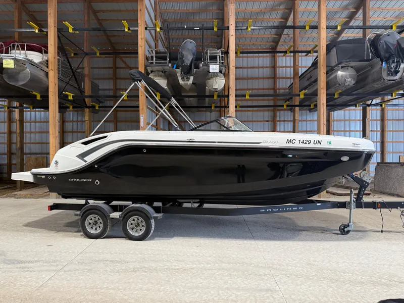 Slide: The Image of 2021 Bayliner DX2250 boat on trailer in storage facility. - 2