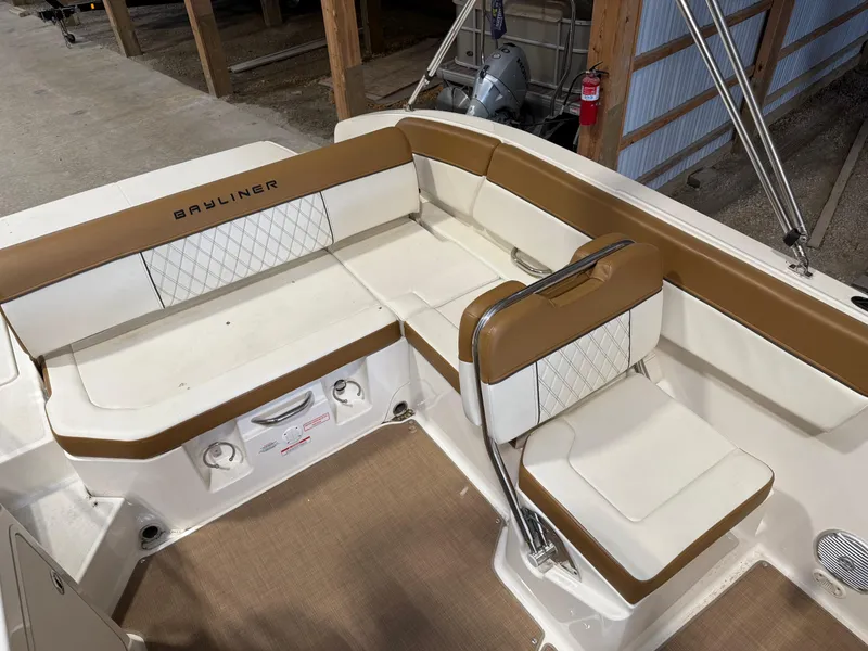 Slide: The Image of 2021 Bayliner DX2250 boat interior with tan and white seating in a storage area. - 4