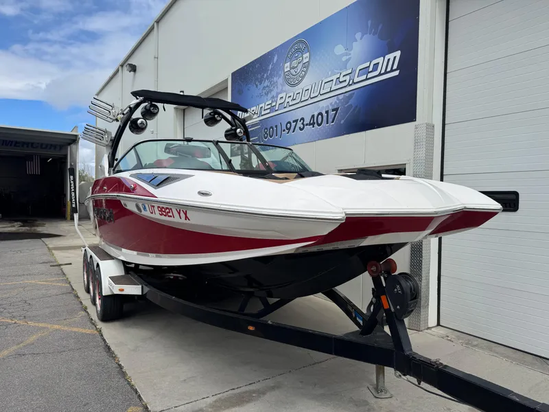 Slide: The Image of 2017 Supra SE 550 boat on trailer outside a building, featuring a sleek red and white design. - 2