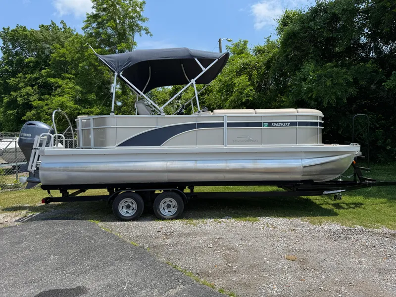 Slide: The Image of 2018 Bennington 22 SLX pontoon boat on trailer, parked outdoors. - 0