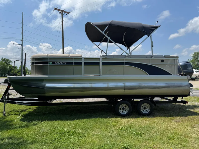 Slide: The Image of 2018 Bennington 22 SLX pontoon boat on trailer, parked on grass under a sunny sky. - 1