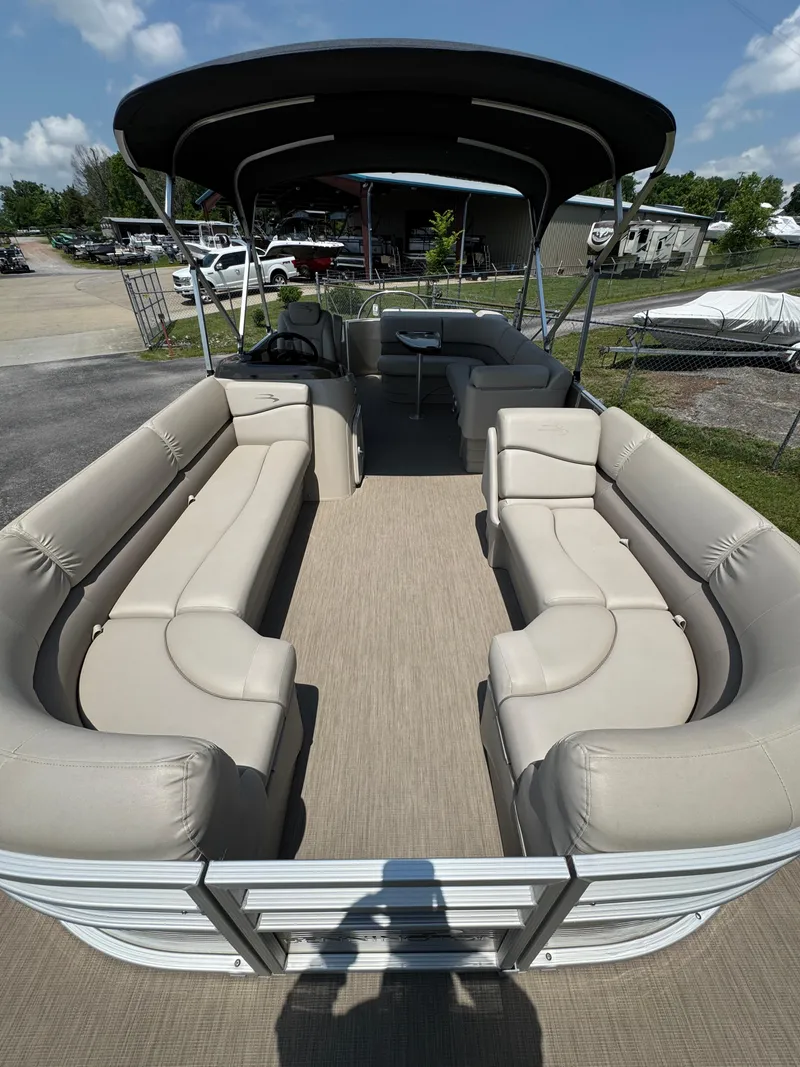 Slide: The Image of 2018 Bennington 22 SLX pontoon boat with spacious seating and canopy, docked outdoors. - 3