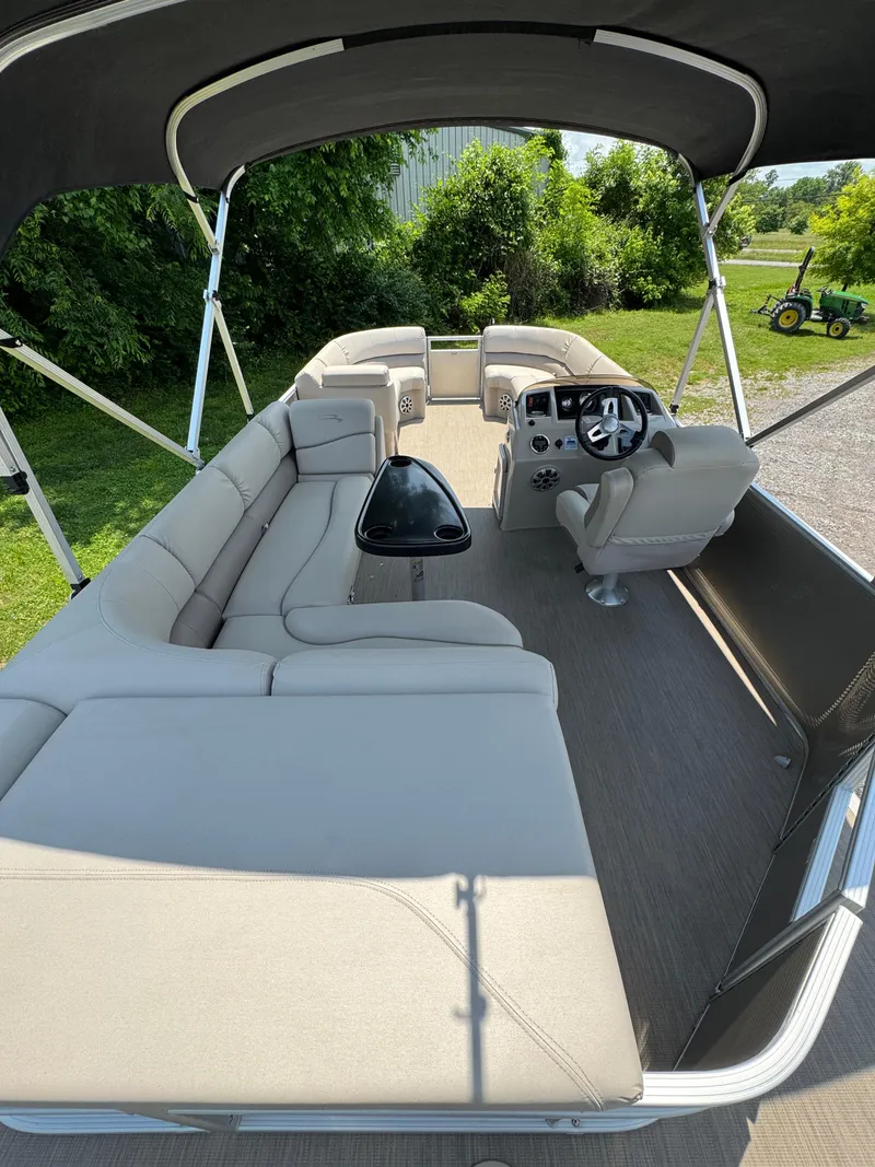 Slide: The Image of 2018 Bennington 22 SLX pontoon boat with spacious seating and canopy, parked outdoors. - 4
