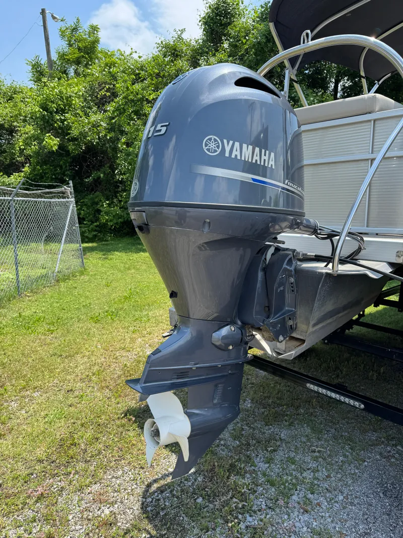 Slide: The Image of 2018 Bennington 22 SLX with Yamaha outboard motor, parked on grass. - 8
