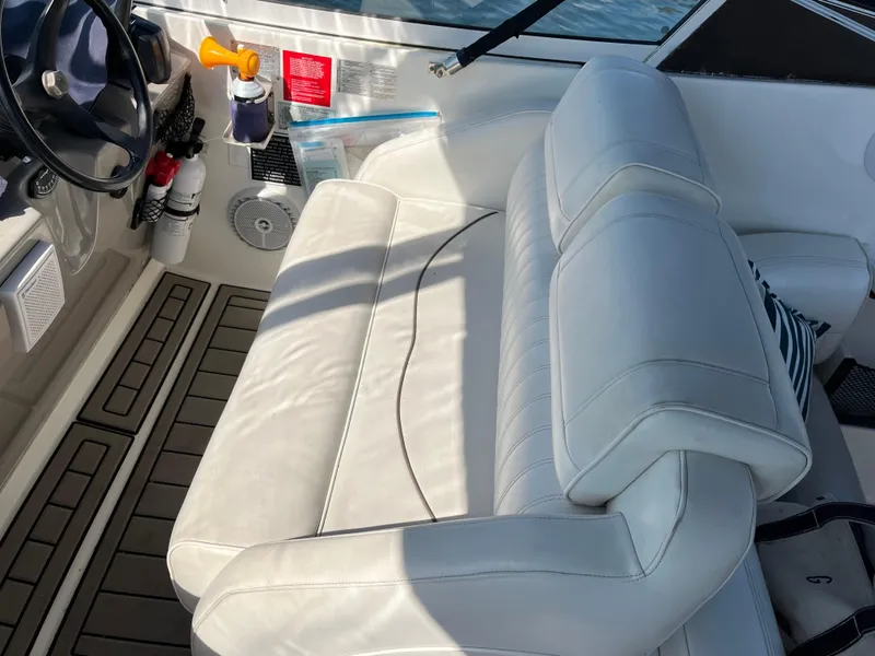 Slide: The Image of 2001 Cruisers Yachts 2870 Express interior with white seating and dashboard details. - 10