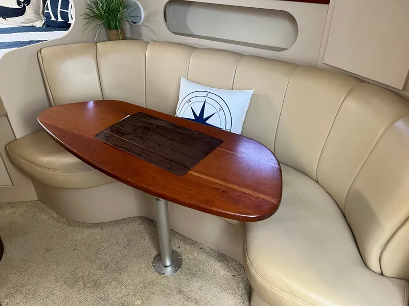 Slide: The Image of 2001 Cruisers Yachts 2870 Express interior with beige seating and wooden table. - 18