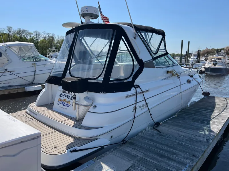 Slide: The Image of 2001 Cruisers Yachts 2870 Express docked at marina, rear view with canopy. - 2