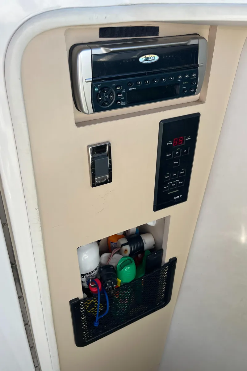Slide: The Image of 2001 Cruisers Yachts 2870 Express control panel with storage compartment and stereo system. - 27