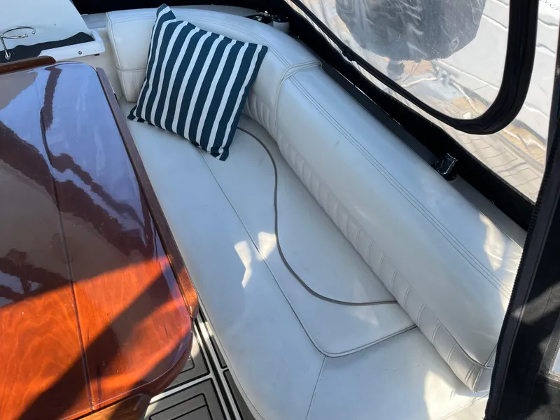 Slide: The Image of 2001 Cruisers Yachts 2870 Express interior with white seating and striped pillow. - 7