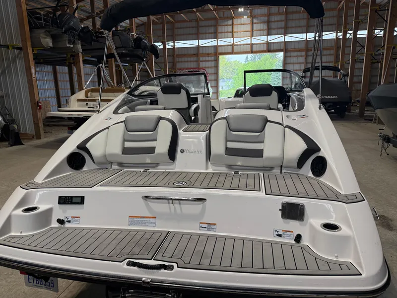 Slide: The Image of 2020 Yamaha Boats 212 in storage, showcasing sleek design and comfortable seating. - 2