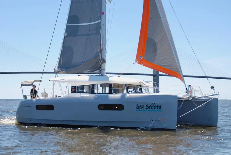 The Image of 2023 Excess 12 catamaran sailing on open water with bridge in background. - 0