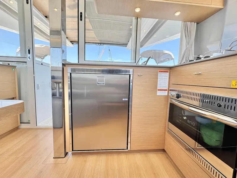 Slide: The Image of Modern kitchen interior on 2023 Excess 12 yacht, featuring stainless steel appliances and wood finish. - 14