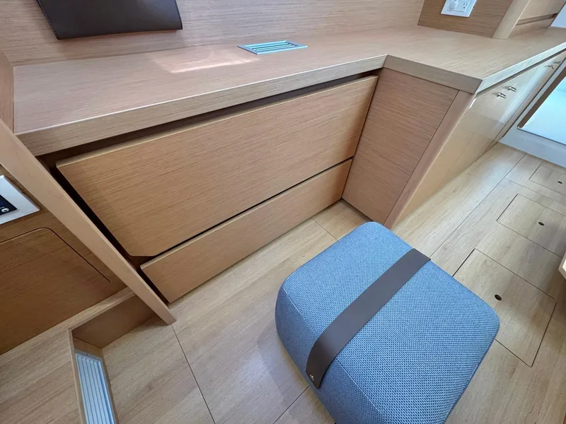 Slide: The Image of 2023 Excess 12 interior with wooden cabinetry and a cushioned stool. - 24