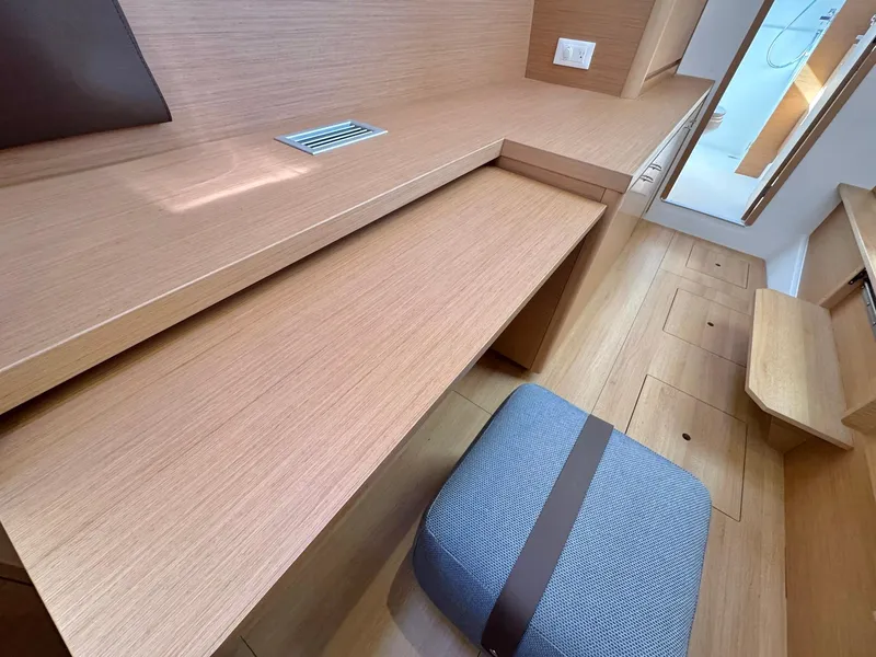 Slide: The Image of Modern interior of 2023 Excess 12 yacht with wooden desk and cushioned stool. - 25