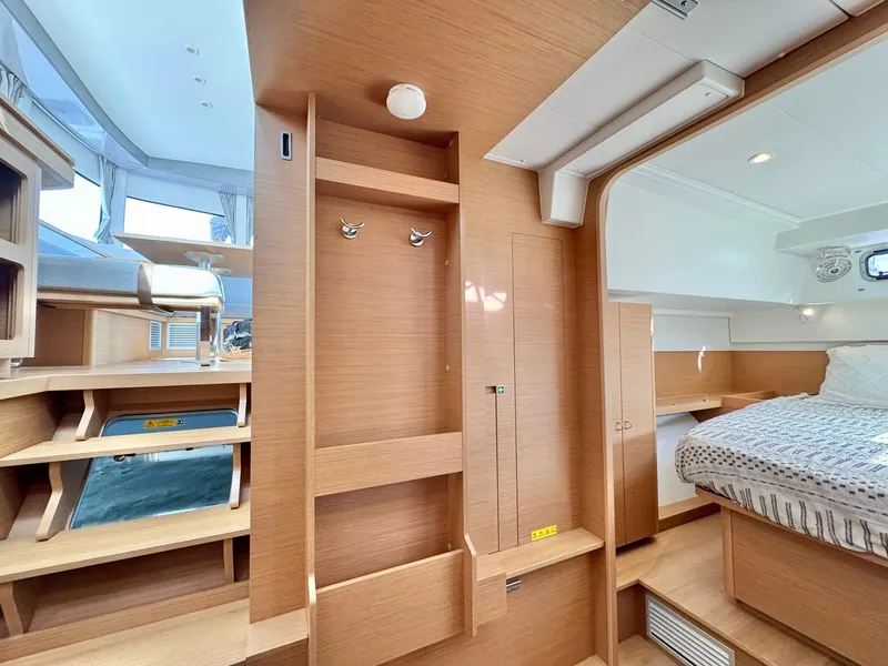 Slide: The Image of 2023 Excess 12 yacht interior with modern wood finish and cozy sleeping area. - 26