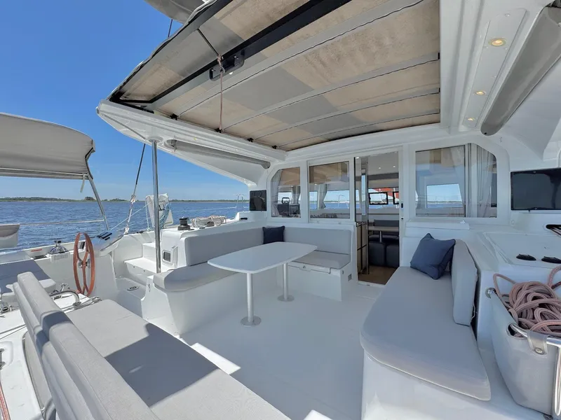 Slide: The Image of Luxurious 2023 Excess 12 catamaran with spacious deck and seating, overlooking serene ocean view. - 3