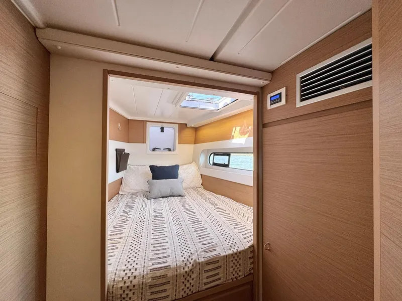 Slide: The Image of 2023 Excess 12 yacht cabin with cozy bed, skylight, and modern wood paneling. - 47