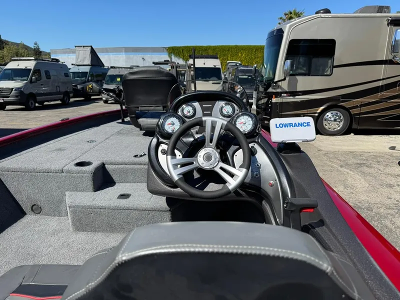 Slide: The Image of 2022 Tracker PRO TEAM 175 TWX boat dashboard with Lowrance electronics, parked near RVs. - 14