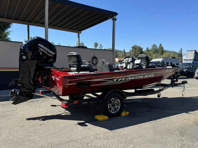 Slide: The Image of 2022 Tracker PRO TEAM 175 TWX boat on trailer, red exterior, parked outdoors. - 3