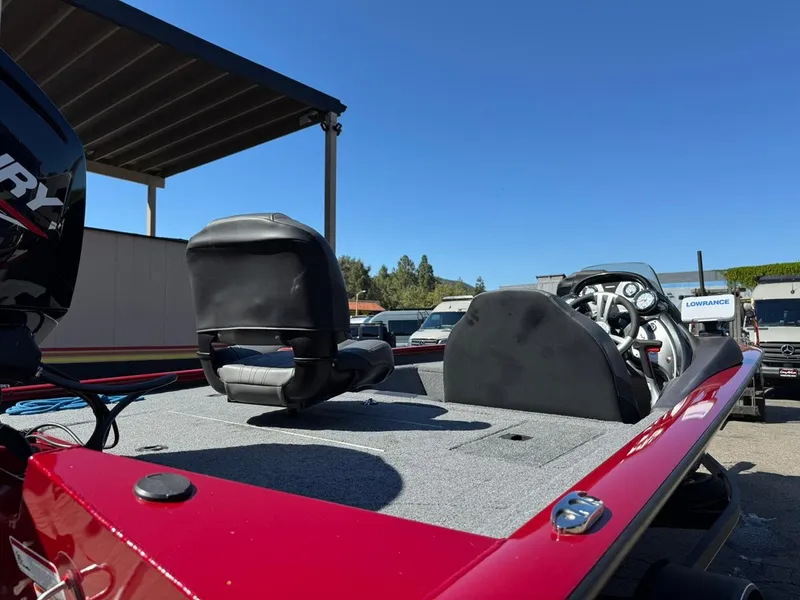 Slide: The Image of 2022 Tracker PRO TEAM 175 TWX boat with red exterior and seating, parked outdoors. - 4